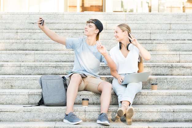 Teenager boy and girl taking a selfie on stairs