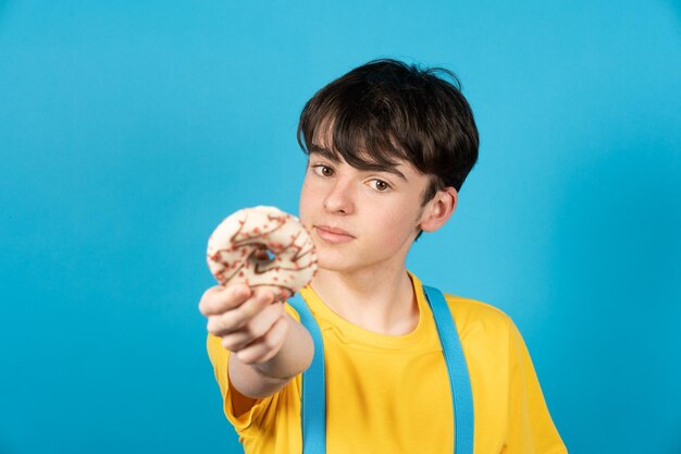 カメラにチョコレート菓子を提供するティーンエイジャーの少年