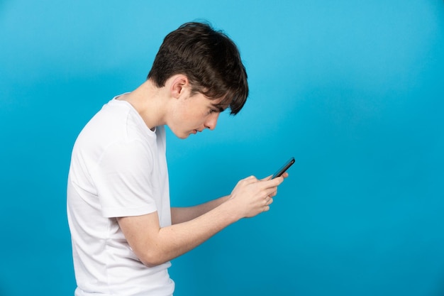 Teenager boy using phone in bad posture digital addiction\
concept