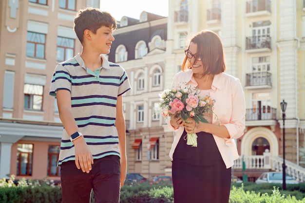 Teenager boy walking with his mother