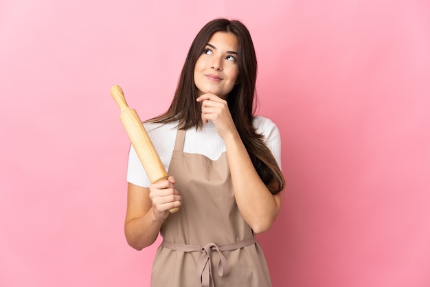 Teenager Brazilian girl holding a rolling pin isolated