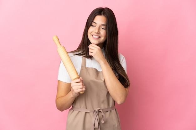 Teenager Brazilian girl holding a rolling pin isolated