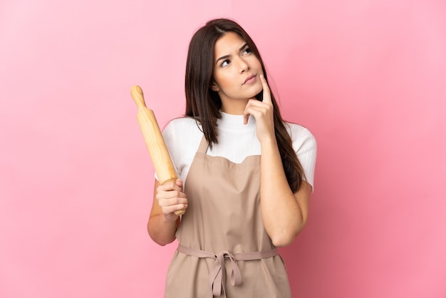 Teenager Brazilian girl holding a rolling pin isolated