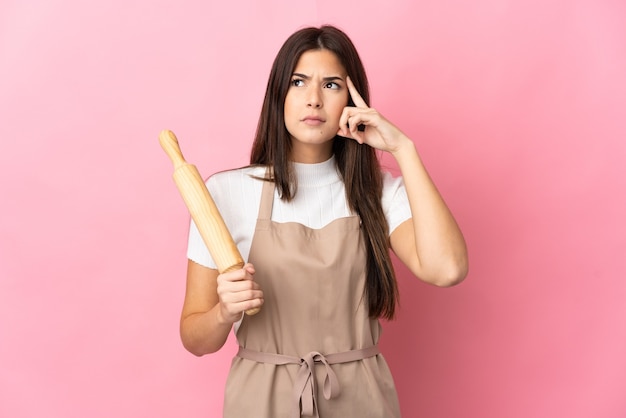 Teenager Brazilian girl holding a rolling pin isolated