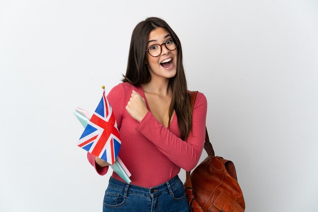 Teenager Brazilian girl holding an United Kingdom flag isolated