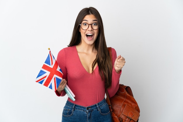 Teenager Brazilian girl holding an United Kingdom flag isolated