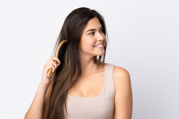 Teenager Brazilian girl with hair comb over wall