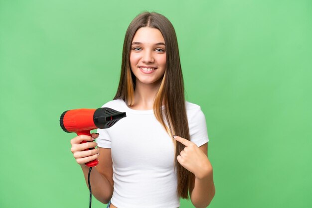 驚きの表情で孤立した背景にヘアドライヤーを保持している 10 代の白人少女