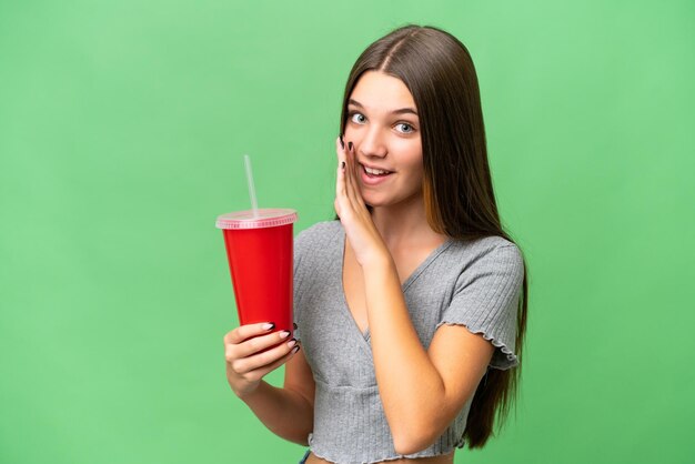 Teenager caucasian girl holding a soda over isolated background whispering something