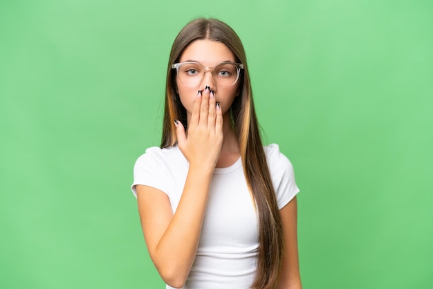 Teenager caucasian girl over isolated background covering mouth with hand