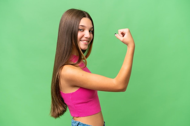 Teenager caucasian girl over isolated background doing strong gesture