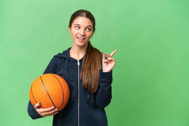 Teenager caucasian girl playing basketball over isolated background intending to realizes the solution while lifting a finger up