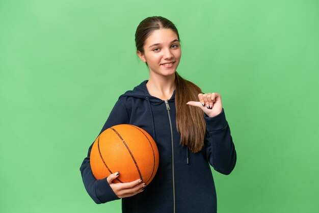 Teenager caucasian girl playing basketball over isolated background proud and selfsatisfied