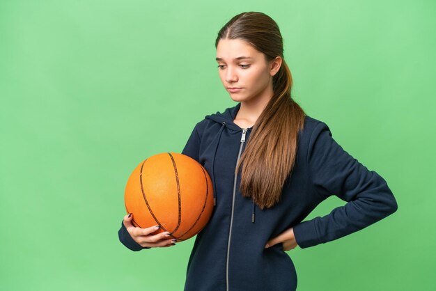 Teenager caucasian girl playing basketball over isolated background suffering from backache for having made an effort