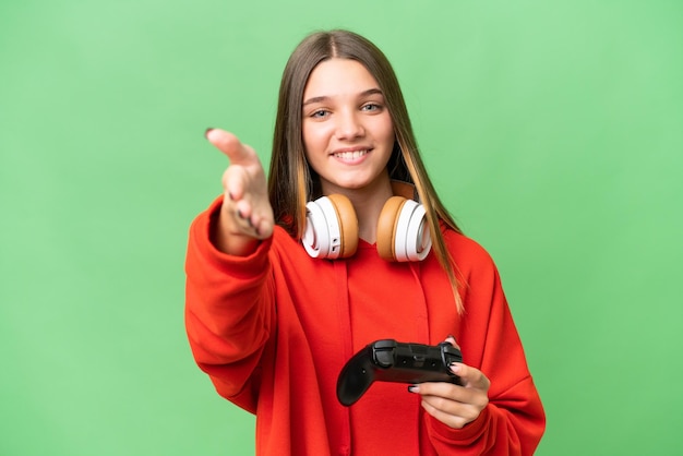 Teenager caucasian girl playing with a video game controller over isolated background