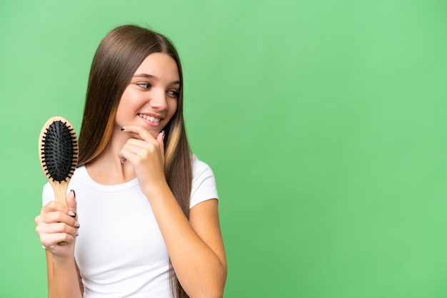 Teenager caucasian girl with hair comb over isolated background thinking an idea and looking side