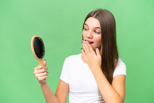 Photo teenager caucasian girl with hair comb over isolated background with surprise and shocked facial expression