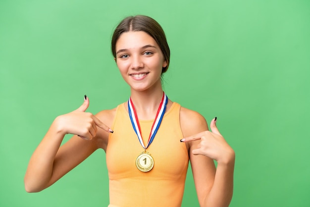 Teenager caucasian girl with medals over isolated background proud and selfsatisfied