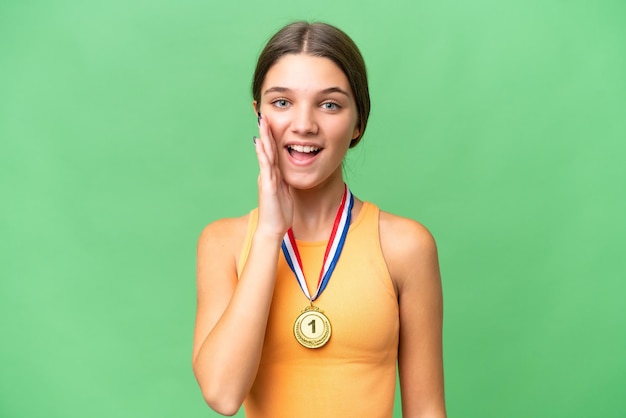 Teenager caucasian girl with medals over isolated background with surprise and shocked facial expression