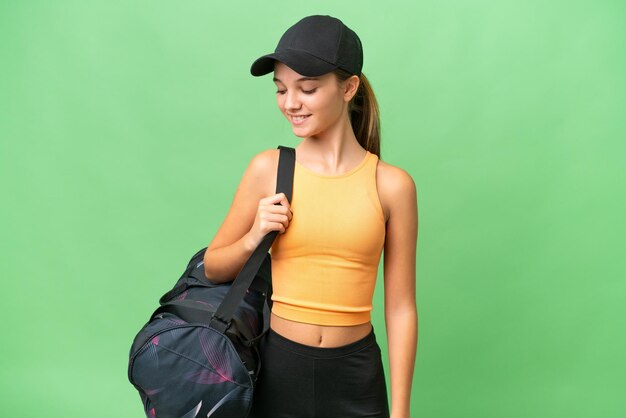 Кавказская девушка-подросток со спортивной сумкой на изолированном фоне со счастливым выражением лица
