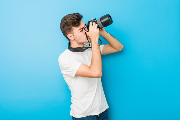 Подросток кавказских человек фотографировать с зеркальной камерой