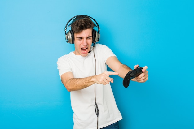 Teenager caucasian man using headphones and game controller