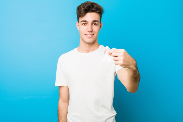 Teenager caucasian man with a pink bow. Concept of fight on cancer.