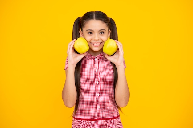 Teenager child girl biting tasty green apple happy teenager positive and smiling emotions of teen girl