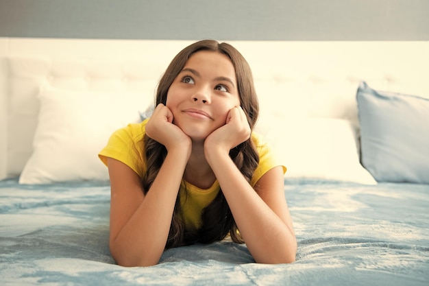 Teenager child girl daydreaming in bed dreaming kids concept Kid lying on bed