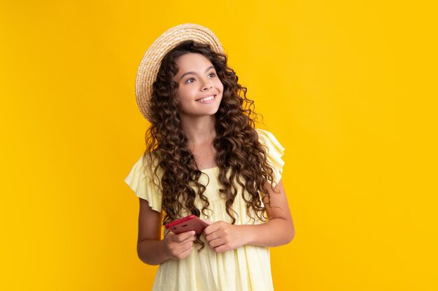 Teenager child girl holding smartphone Hipster girl with cell phone Kid hold mobile phone texting in online social networks Happy teenager positive and smiling emotions of teen girl