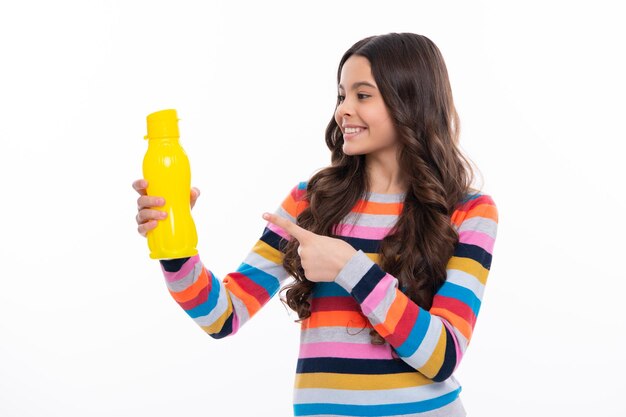 Teenager child girl with water from plastic bottle on isolated background copy space Kid girl care body hydration Active leisure and water balance Happy girl face positive and smiling emotions