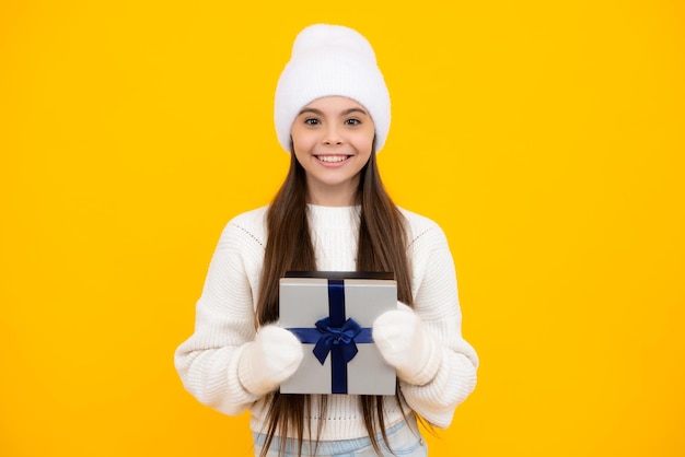 Teenager child hold gift on birthday Funny kid girl in winter wear holding gift boxes celebrating happy New Year or Christmas Winter holiday