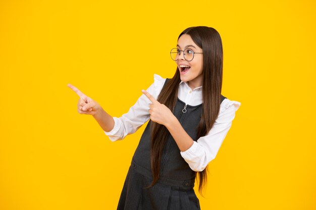 Teenager child pointing to the side with a finger to present a product or idea Teen girl in casual 