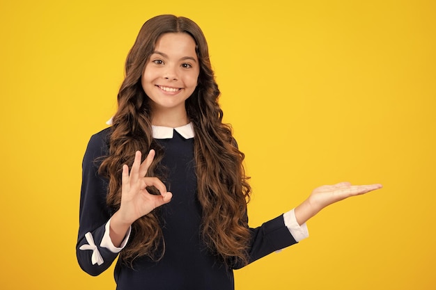 Teenager child pointing to the side with a finger to present a product or idea teen girl in casual