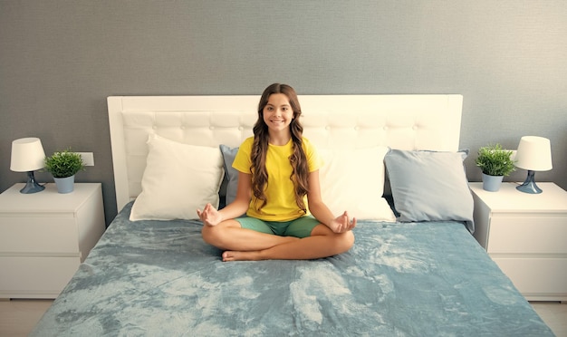 Teenager child practicing meditation at bedroom morning\
meditation on bed