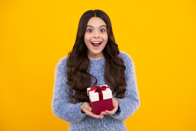 Teenager child in winter wear holding gift boxes celebrating\
happy new year or christmas winter kids holiday amazed teenager\
excited teen girl