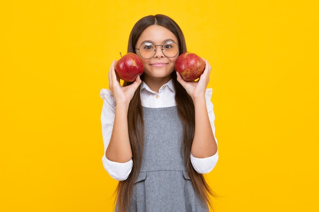 Teenager child with apple on yellow isolated background apples are good for children Happy girl face positive and smiling emotions