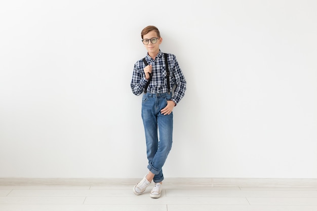 Teenager, children and fashion concept - kid dressed in plaid shirt posing over white background
