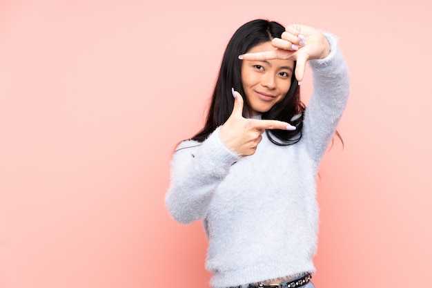 Teenager Chinese woman isolated on pink