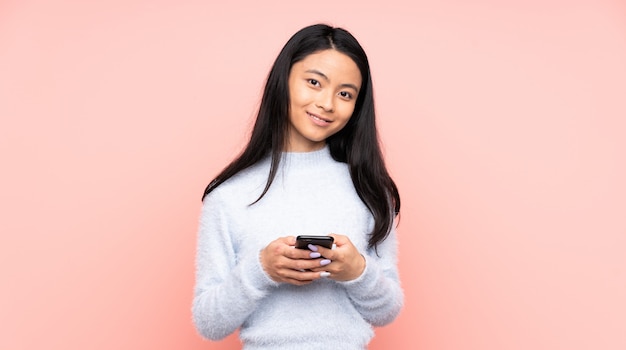 Teenager Chinese woman isolated on pink