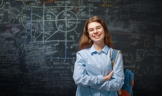 Teenager in class on background of blackboard