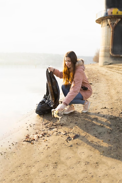 Teenager cleaning the beach from plastic bags