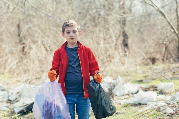  teenager collects garbage bags in the woods a volunteer