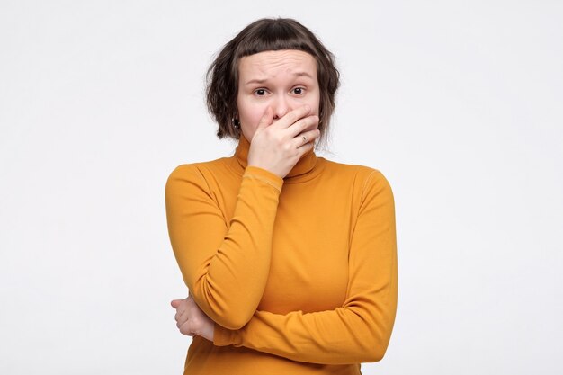 Teenager covers mouth with hand