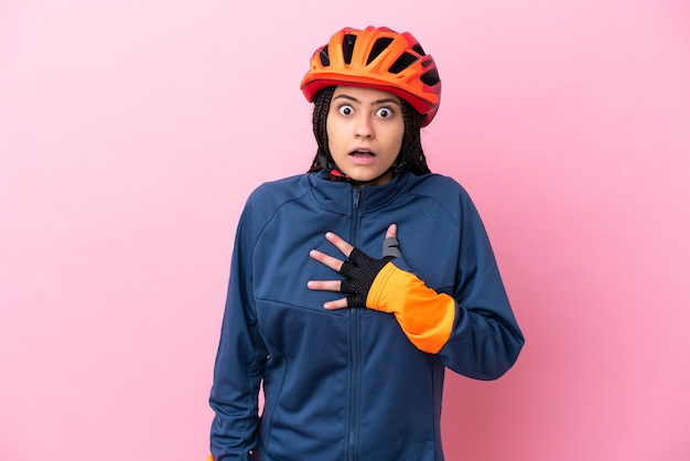 분홍색 배경에 격리된 10대 자전거 소녀는 오른쪽을 보고 있는 동안 놀라고 충격을 받았습니다.