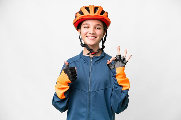 Teenager cyclist girl over isolated white background showing ok sign and thumb up gesture