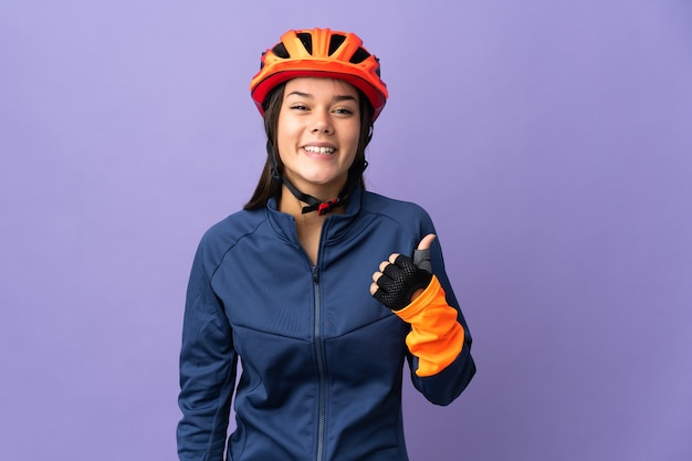 Teenager cyclist girl pointing to the side to present a product