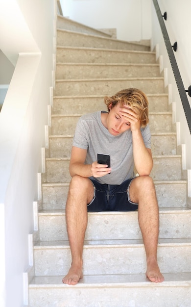 Teenager depressed sitting on stairs at home