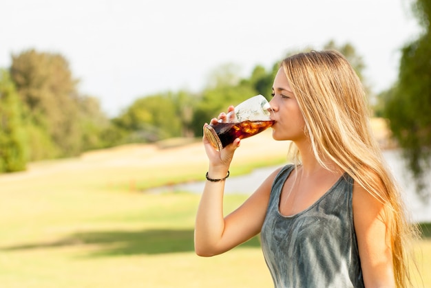 Teenager drinking a glass of soda