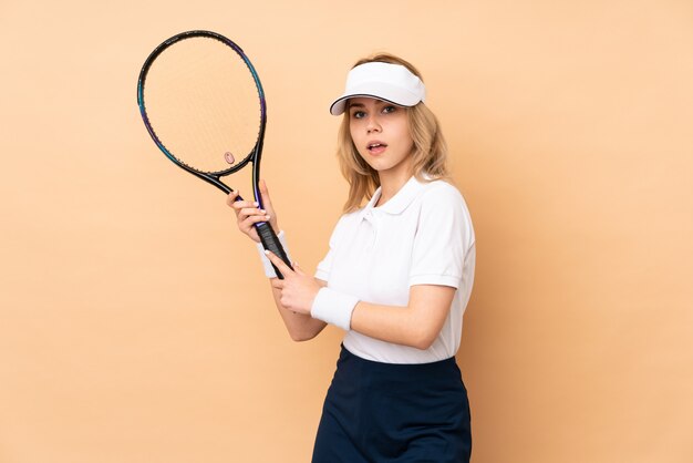 テニスをしているベージュのティーンエイジャーの女の子